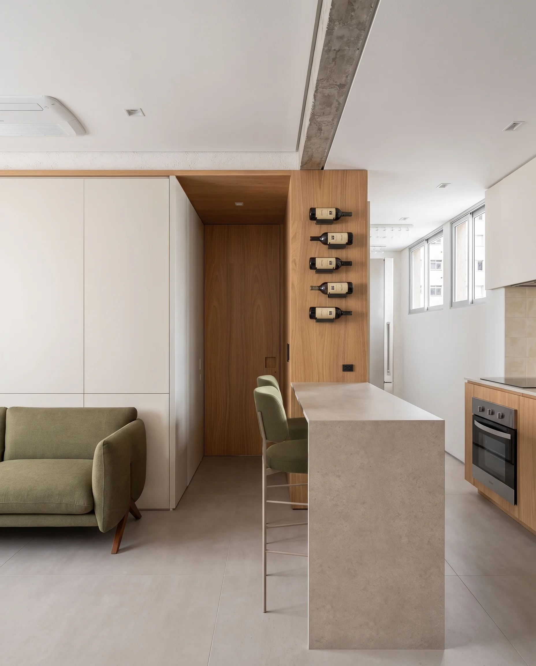 Vista de la isla de cocina del Apartamento LNC, que mantiene la misma madera y encimera neutra en un ángulo más cercano